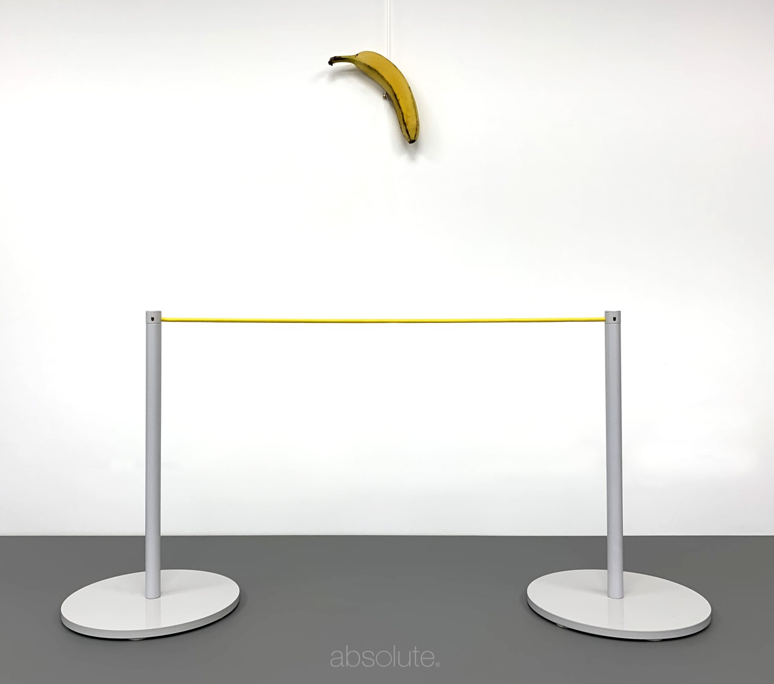Absolute's recreation of 'Comedian' by Maurizio Cattelan, protected from consumption using white freestanding barriers connected by yellow barrier cord.